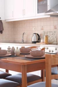 a kitchen with a wooden table with dishes on it at Spacious Lovely Apartment in Sarandë
