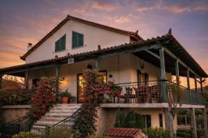 a house with a balcony and a sunset at Estate Tsiati in Piryiótika