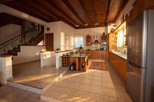 a large kitchen with wooden cabinets and a staircase at Estate Tsiati in Piryiótika +57 photos