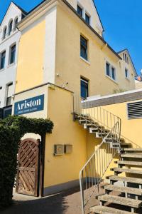 a yellow building with a door and stairs in front at Gästehaus Bock in Lahnstein