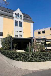 a building with a hedge in front of a building at Gästehaus Bock in Lahnstein