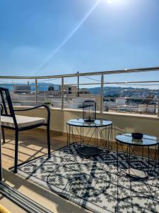 a patio with two tables and a chair on a balcony at Casa Georgia in Kefalos