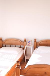 two twin beds in a room with a side table at Spacious Lovely Apartment in Sarandë