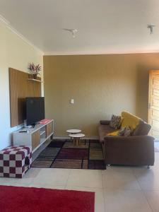 a living room with a couch and a table at Apartamento Aconchegante 2 Quartos in Tabapira