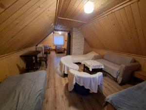 a attic room with a couch and tables in a room at Leśna chatka in Wilga