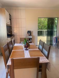 a dining room with a table with chairs and a kitchen at Apartamento Aconchegante 2 Quartos in Tabapira