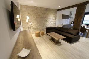 a living room with a black couch and a table at Le Moulin d'Oscar & Spa - Mulhouse Nord in Baldersheim