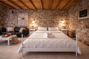 a bedroom with a bed and a stone wall at Estate Tsiati in Piryiótika