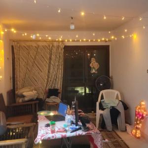 a living room with a table and lights on the ceiling at A ROOM in mandara in Alexandria