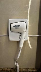 a white hair dryer is hanging on a wall at Departmento en Barrio Antiguo in Monterrey