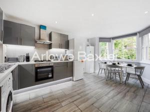 a kitchen with stainless steel appliances and a table at Hackney Guest Rooms in London