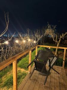 a bench sitting on a deck at night at Cozy Forest Cabin in Tirana