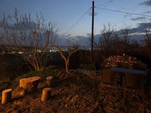 a table and chairs sitting in a yard at night at Cozy Forest Cabin in Tirana