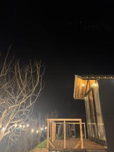 a house with two chairs on a deck at night at Cozy Forest Cabin in Tirana