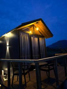 a tiny house on a deck at night at Cozy Forest Cabin in Tirana