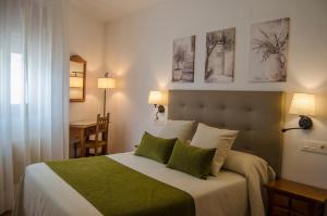 ein Schlafzimmer mit einem großen Bett mit grün-weißer Bettwäsche in der Unterkunft Las Perdices in Válor