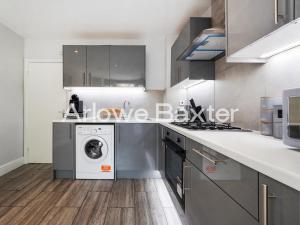 a kitchen with a washer and a washing machine at Hackney Guest Rooms in London