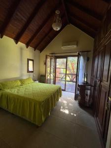 a bedroom with a green bed and a large window at Rincón del Cielo Country Club in Merlo +15 photos