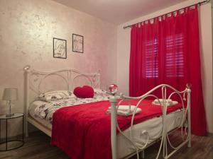 a bedroom with a white bed with a red blanket at Pomerino Apartmans in Pomer +54 photos