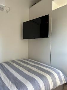 a bedroom with a bed with a flat screen tv on the wall at Petit Luxe in Mortroux
