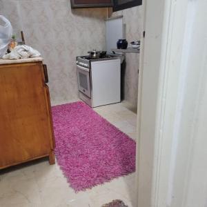 a kitchen with a pink rug on the floor at A ROOM in mandara in Alexandria