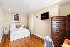 a bedroom with a white bed and a dresser at Orien tal By My Getaways in Brighton & Hove +43 photos