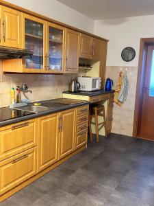 a kitchen with wooden cabinets and a counter top at Penzion U Kuboňů in Volary