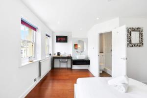 a white room with a bed and a desk at Orien tal By My Getaways in Brighton & Hove
