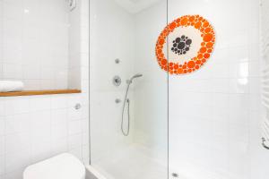 a bathroom with a shower with an orange circle on the wall at Orien tal By My Getaways in Brighton & Hove