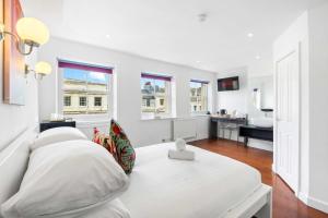 a white room with a bed and a bathroom at Orien tal By My Getaways in Brighton & Hove