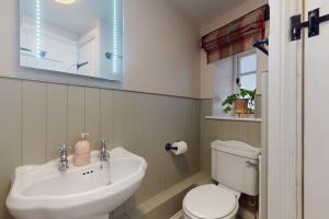 a bathroom with a sink and a toilet at The Barn Timberscombe in Timberscombe +10 photos