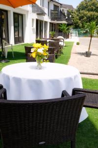a table with a vase of yellow flowers on it at Hotel La Baie Royale in Pontorson