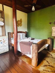a bedroom with two beds and a green wall at Pousada Lapralapa in Santana do Riacho