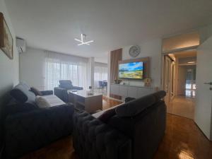 a living room with couches and a flat screen tv at Apartman Mirjana 2 spavace odvojene sobe in Banja Luka