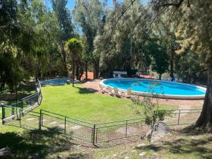 a large swimming pool in a yard with trees at Rincón del Cielo Country Club in Merlo