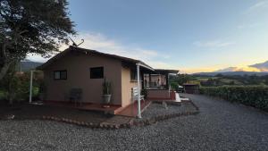 a small house with a porch on a gravel road at Antara House in Guasca