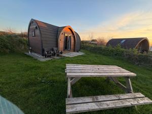 a wooden bench in front of a tiny house at Glamping Pods Nr Port Isaac in Port Isaac