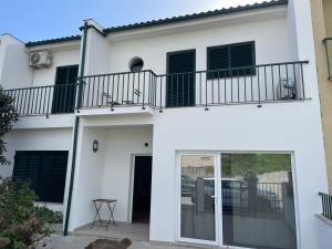 a white house with a balcony at You have to love Amarante in Amarante