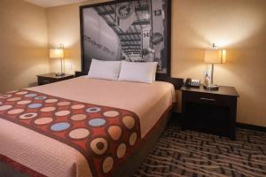 a hotel room with a bed and two lamps at Super 8 by Wyndham Pasadena in Pasadena