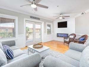 a living room with two couches and a tv at Brass Rail 310 in Tybee Island