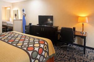 a hotel room with a bed and a desk with a computer at Super 8 by Wyndham Pasadena in Pasadena