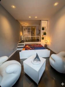 a bedroom with a bed and two white chairs at Silver Flat in Vernazza