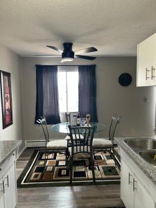 a kitchen with a table and chairs and a dining room at Exquisite 2 Bedroom Apartment in Camrose