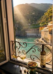 a window with two wine glasses and a bottle of wine at Silver Flat in Vernazza
