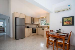 a kitchen with a table and a stainless steel refrigerator at Apartment Margerita in Asgourou