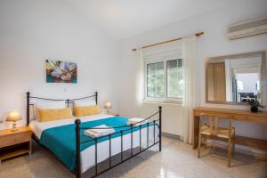 a bedroom with a bed and a desk and a window at Apartment Margerita in Asgourou +36 photos