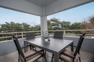 a table and chairs on the balcony of a house at Apartment Margerita in Asgourou