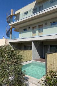 ein Wohnhaus mit einem davorliegenden Swimmingpool in der Unterkunft Casa C Hôtel & Spa in Propriano