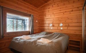a bedroom with a bed in a log cabin at Mökki Vierumäki in Myllykylä