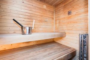 a wooden sauna with a bucket and a metal cup at Mökki Vierumäki in Myllykylä
